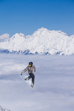 Flying snowboarder on mountains