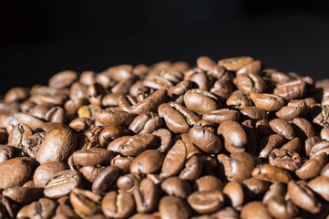 Background of roasted coffee beans lit by the sun