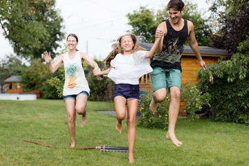 Familie läuft über einen Wassersprenger