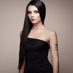 Naklejka premium Fashion portrait of elegant woman with magnificent hair. Brunette girl. Perfect make-up. Girl in elegant dress. Flash tattoo gold