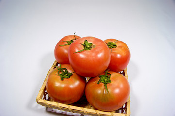 竹かごに入った5個の日本産トマト
