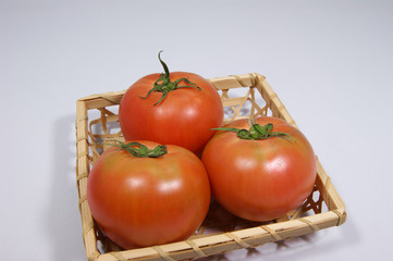 竹かごに入った3個の日本産トマト