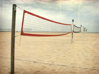 aged and worn vintage photo of volleyball net on beach