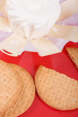 cream cheese in an environmentally friendly packaging made of wood with a round pastry on the red plate, top view, side view,
