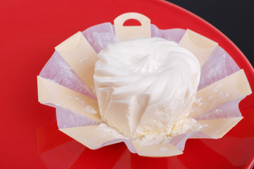 cream cheese in an environmentally friendly packaging timber on a red plate, top view, side view,