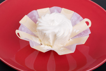 cream cheese in an environmentally friendly packaging timber on a red plate, top view, side view,