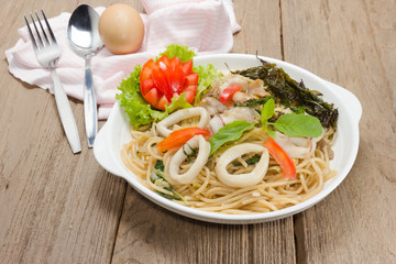 stir fried spaghetti with squid on wood background
