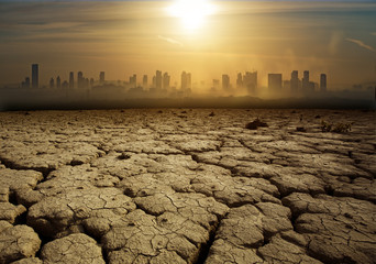 Global Warming and pollution theme with cracked land and the cityscape