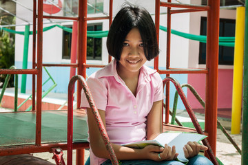 cute asian girl read your book at playground