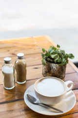 Hot art Latte Coffee in a cup on wooden table and Coffee shop bl