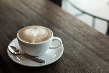 Hot art Latte Coffee in a cup on wooden table and Coffee shop bl