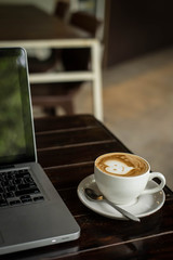 Hot art Latte Coffee in a cup on wooden table and Coffee shop bl