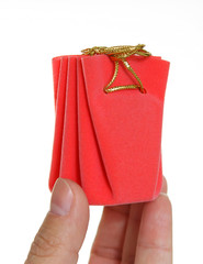Hand holds a red box with a gift
