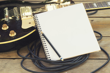 electricguitar with notepad on wood table