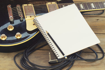 electricguitar with notepad on wood table