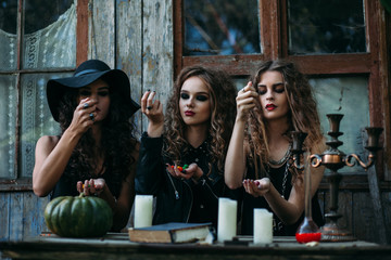 Three vintage witches perform magic ritual