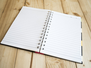 Notebook page 1 - One blank notebook page on wood table, business concept