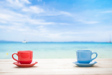 Two cups of coffee on table with sea