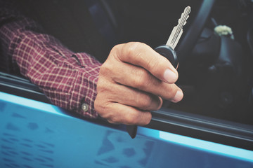 Man holding keys with car