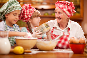 Grandmother,grandson And Granddaughter chef Baking In Kitchen