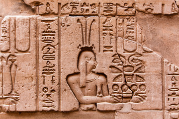 Egyptian hieroglyphics on the stone wall. Ancient stone carved E