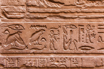 Egyptian hieroglyphics on the stone wall. Ancient stone carved E