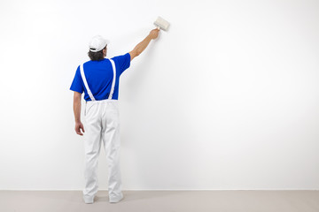 Painter with paintbrush on white wall © guerrieroale