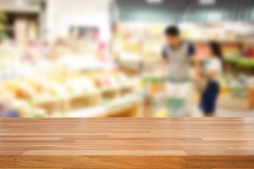 Empty wooden table and people shopping at supermarket  backgroun
