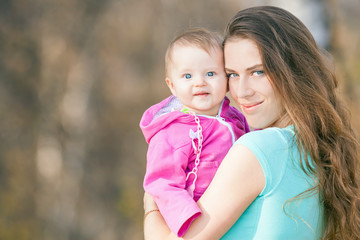 Happy child and beautiful mother outdoor at autumn park