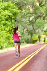 Fototapeta premium Running woman - female runner training on road