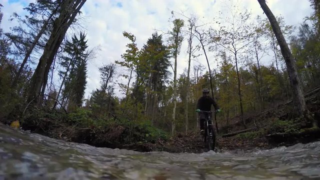 Water splashing as mountain biker crosses the creek