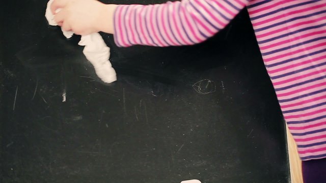 Little girl clear the blackboard