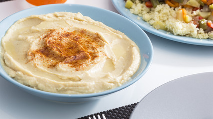 Tasty arabic hummus food served on a blue bowl with rice and spices