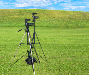 two camera mounted on tripods ready to film an outdoor performance 