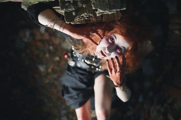 Fototapeta na wymiar Portrait girl with red hair and bloody face vampire, murderer, psycho, halloween theme, bloody woman
