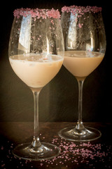 Irish cream liqueur in a glass with ice with a pink sugar