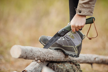 woman cutting a wood with a hand saw