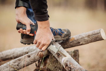 Man cutting a wood with a hand electric saw