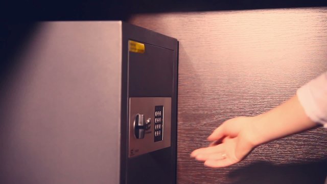 woman opens a safe checks documents and closes the evening