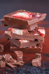 Stack of chocolate slices strawberry on a dark background.