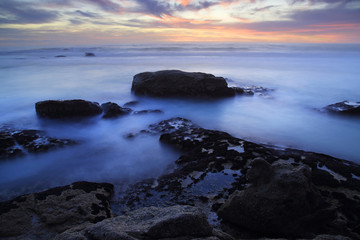 Fototapeta na wymiar Twilight / A seascape at twilight, rocks washed by the sea under a sunset afterglow