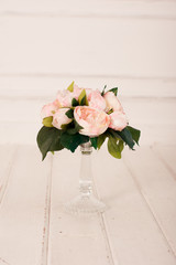 Wedding bouquet with roses on white wooden floor closeup in room