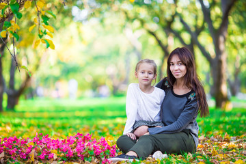 Adorable little girl with mother in autumn park outdoors