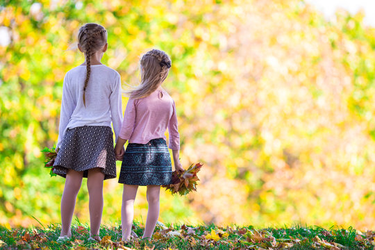 Little adorable girls outdoors at warm autumn day