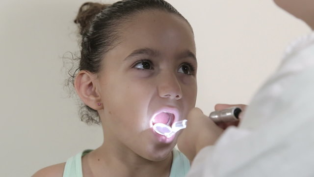 Young girl open her mouth at the dentist