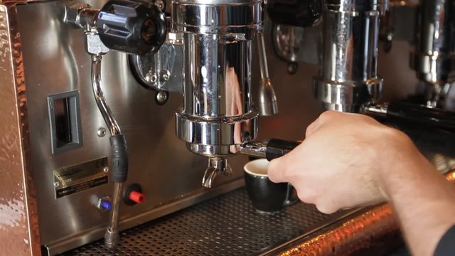 Espresso Machine Pour Wide. Shot dollies from left to right as employee places in espresso portafilter and makes an espresso.
