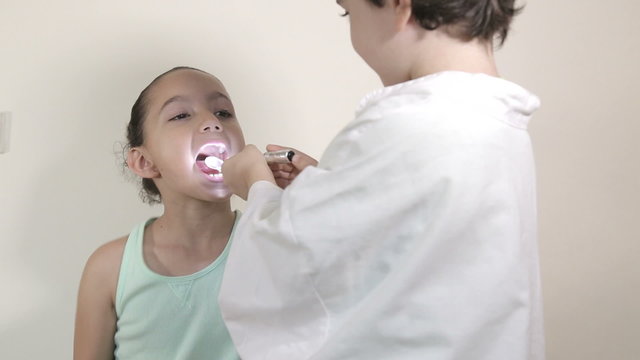 Young kids role play patient at the dentist