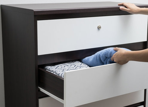 Woman hand open drawer and picking up Towel