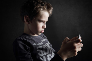 enfant 12 ans jouant sur tablette