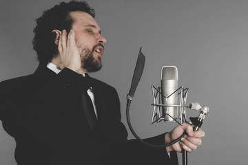 artist of the song, singer suit and microphone